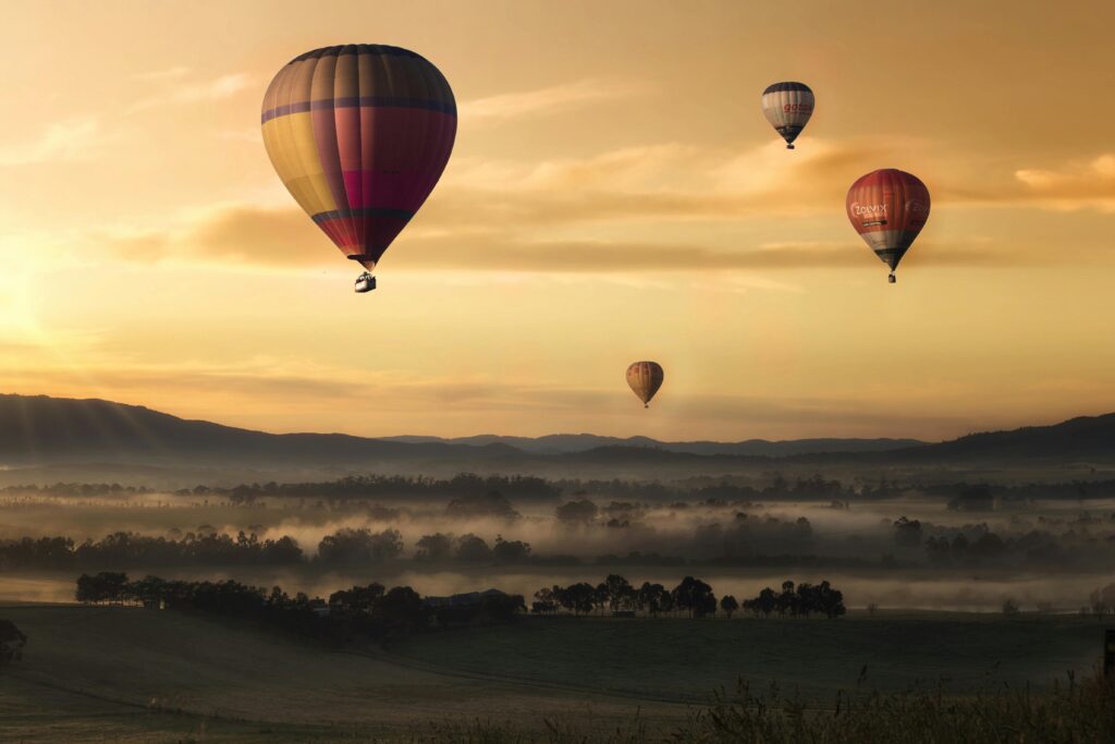 Werkwijze Hot air balloons floating over misty fields at sunrise, creating a picturesque adventure scene.